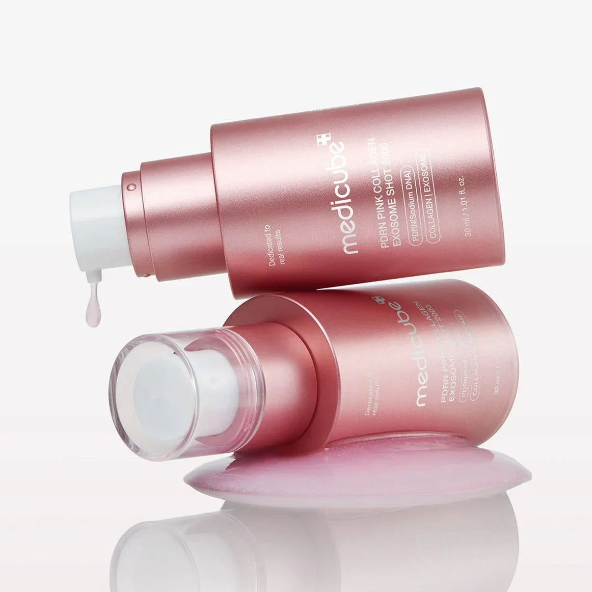 Medicube PDRN Pink Collagen Exosome Shot 2000 skincare serum with dropper, glowing pink liquid on reflective surface